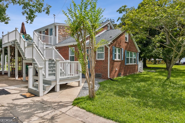 exterior space with a lawn, stairway, roof with shingles, crawl space, and brick siding