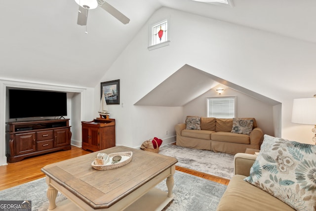 living room with light wood-type flooring, a ceiling fan, and vaulted ceiling