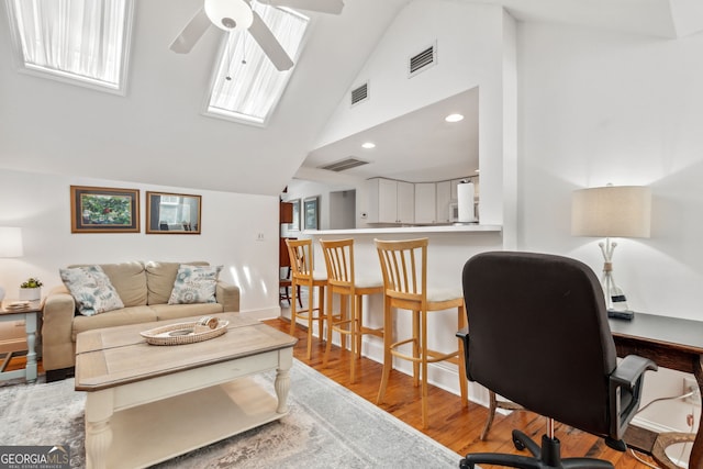 living area featuring a ceiling fan, visible vents, and light wood finished floors