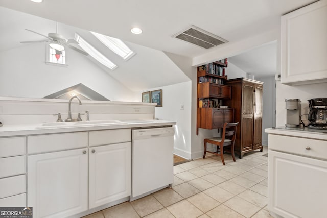 kitchen with visible vents, vaulted ceiling with skylight, white dishwasher, a sink, and white cabinets