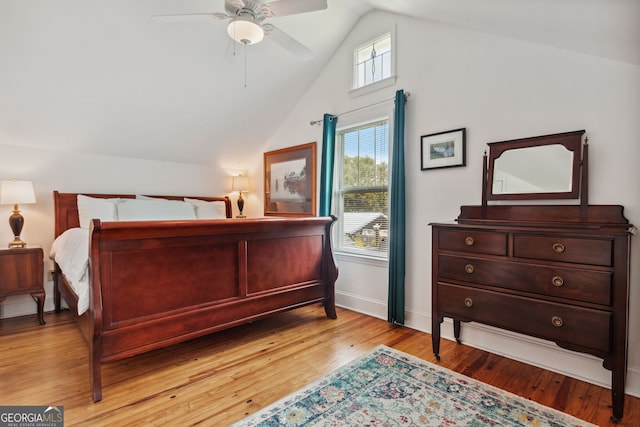 bedroom featuring baseboards, lofted ceiling, light wood-style floors, and a ceiling fan