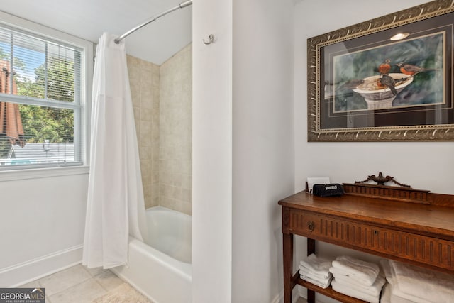 bathroom featuring tile patterned flooring, shower / tub combo with curtain, and baseboards