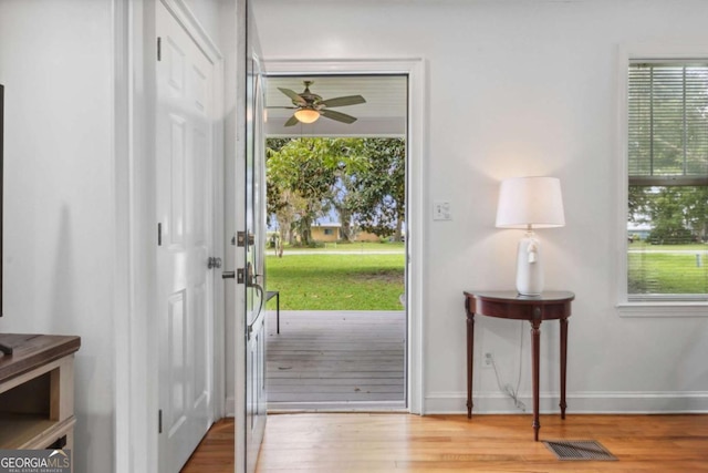 entrance foyer with visible vents, ceiling fan, baseboards, and wood finished floors