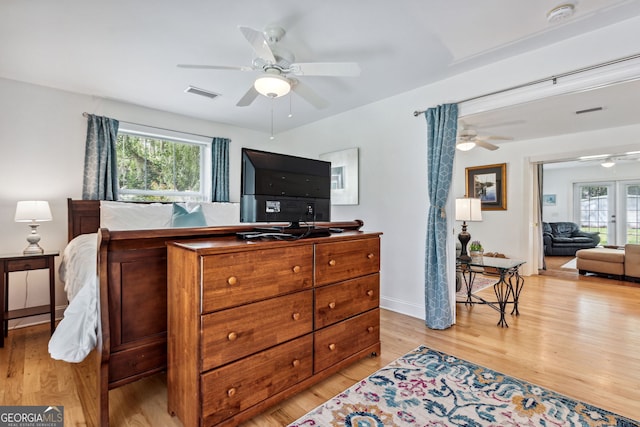 bedroom featuring french doors, multiple windows, visible vents, and light wood-style flooring