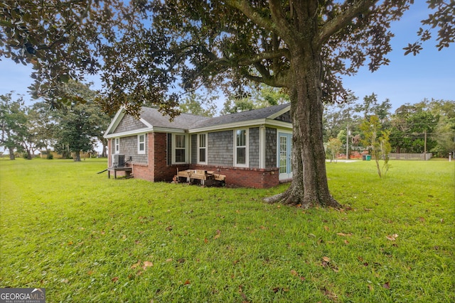 view of side of property with a yard and a shingled roof