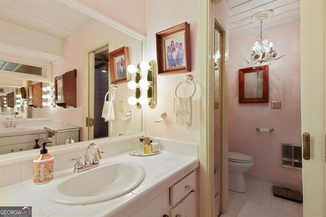 bathroom with vanity, tile patterned flooring, toilet, a notable chandelier, and heating unit