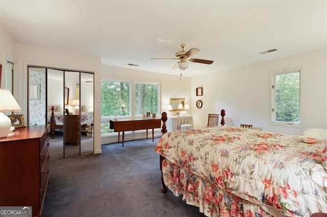 bedroom with a closet, dark carpet, and ceiling fan