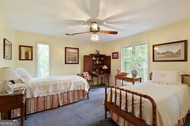 bedroom with ceiling fan and dark colored carpet