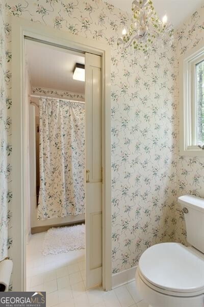 bathroom with a chandelier and toilet