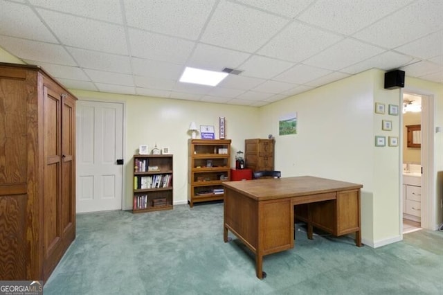 carpeted office space with a paneled ceiling