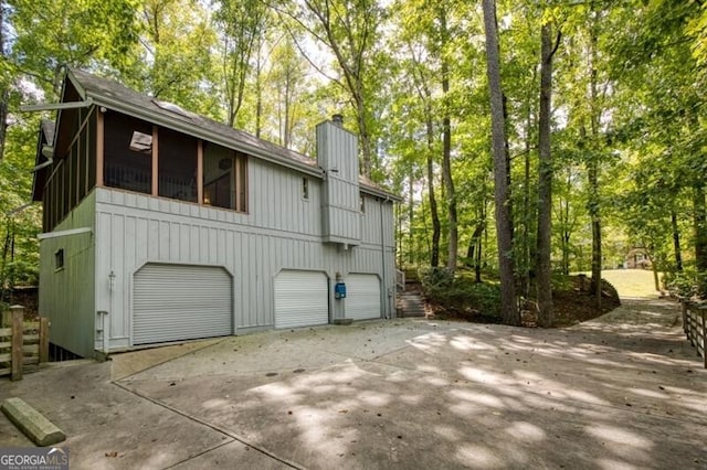 view of side of property featuring a sunroom and a garage