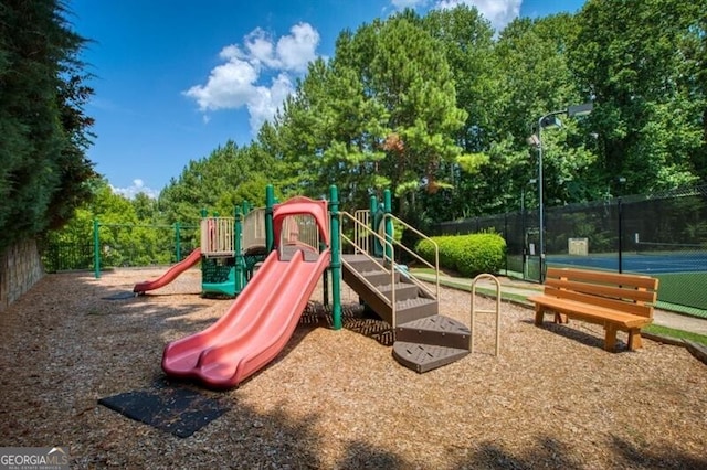 view of jungle gym featuring tennis court