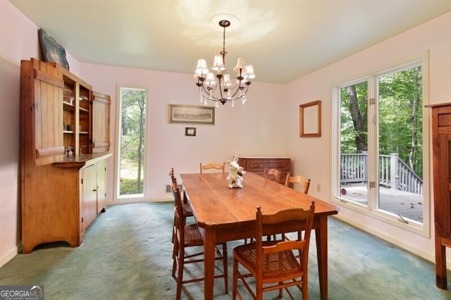 dining area with dark colored carpet and a notable chandelier