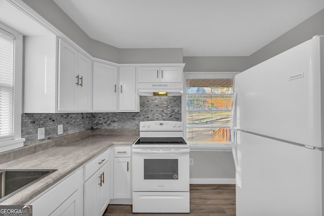 kitchen featuring white cabinets, plenty of natural light, decorative backsplash, and white appliances