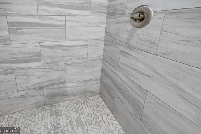 interior details featuring a tile shower