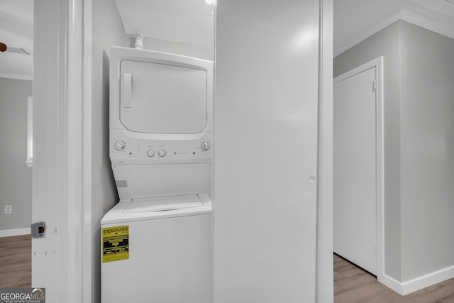 laundry area featuring light hardwood / wood-style floors and stacked washer / drying machine