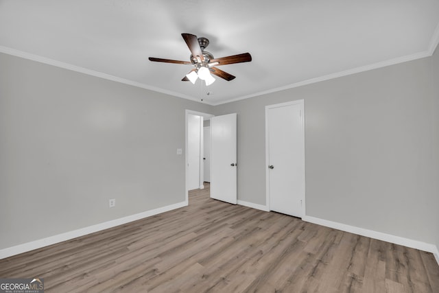 unfurnished room featuring ceiling fan, light wood-type flooring, and crown molding