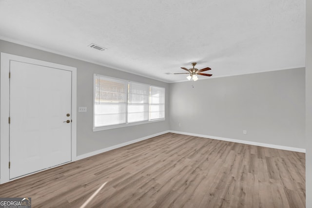 foyer entrance with ceiling fan, a textured ceiling, and light wood-type flooring