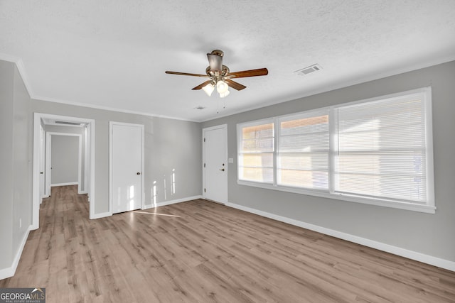 unfurnished room featuring a textured ceiling, light hardwood / wood-style flooring, ceiling fan, and crown molding