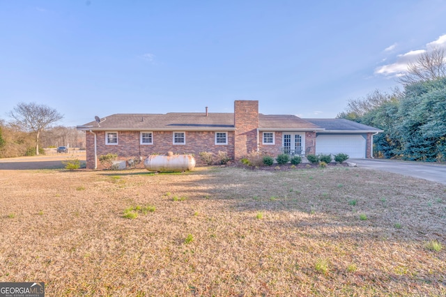 ranch-style house featuring a garage and a front lawn