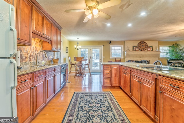 kitchen featuring white fridge, light stone counters, a healthy amount of sunlight, and sink