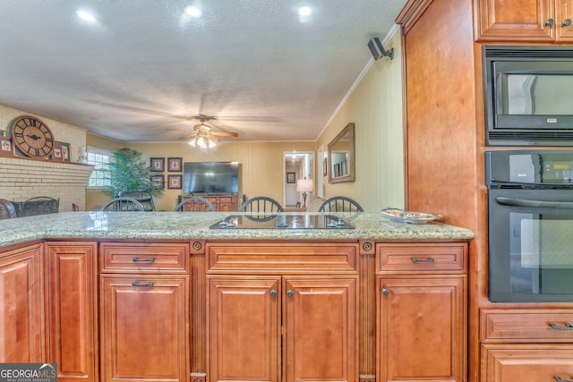 kitchen with light stone countertops, a textured ceiling, ceiling fan, crown molding, and black appliances