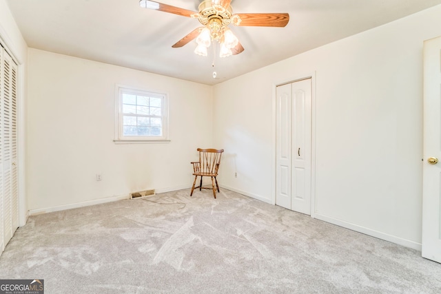 unfurnished bedroom with ceiling fan and light colored carpet