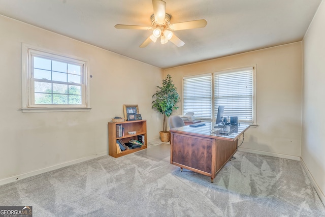 home office with plenty of natural light, ceiling fan, and light carpet