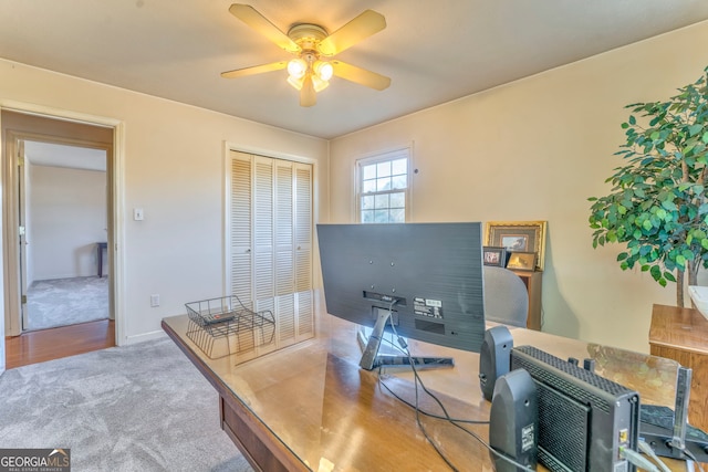 carpeted home office with ceiling fan