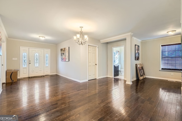 foyer entrance featuring crown molding, dark wood-type flooring, and a chandelier