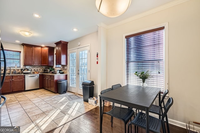 kitchen featuring decorative backsplash, french doors, light wood-type flooring, ornamental molding, and dishwasher