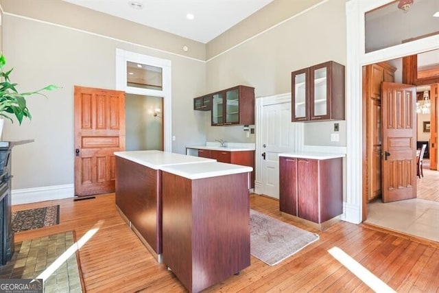 kitchen with a kitchen island, a fireplace, and light hardwood / wood-style flooring