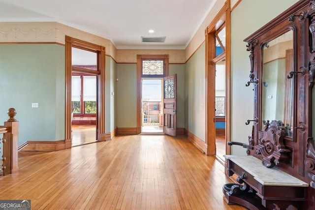 entryway featuring light hardwood / wood-style floors and crown molding