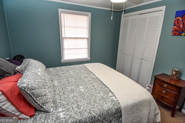 bedroom with carpet flooring, a closet, crown molding, and ceiling fan