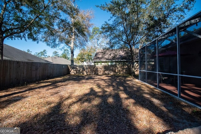 view of yard with a lanai and a fenced backyard