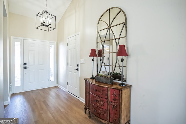 foyer entrance with light wood-type flooring and an inviting chandelier