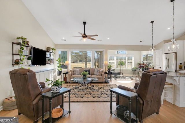 living room featuring ceiling fan, high vaulted ceiling, and light hardwood / wood-style floors