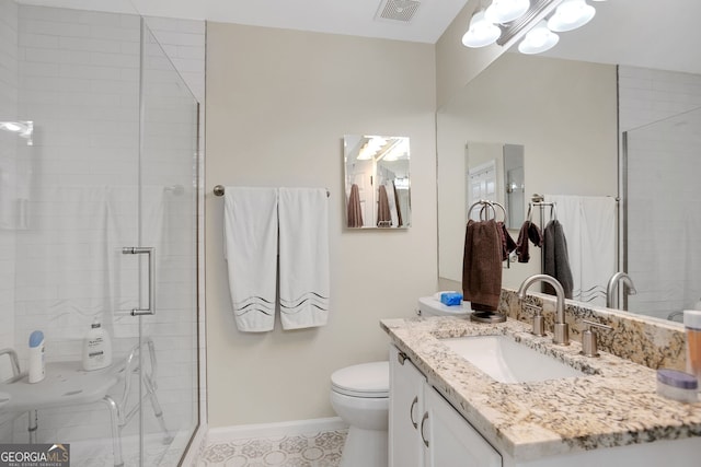 bathroom with vanity, toilet, and a shower with door