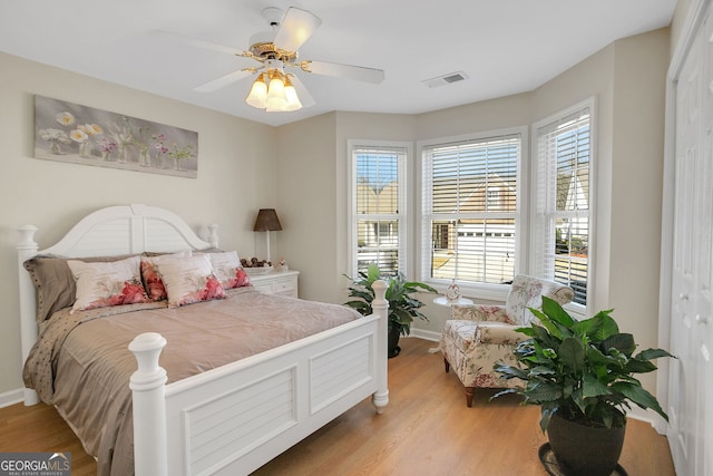 bedroom featuring ceiling fan, light hardwood / wood-style flooring, and a closet