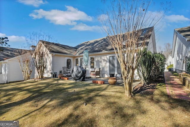 rear view of property featuring a yard and a patio