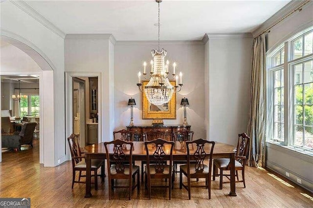 dining area featuring a healthy amount of sunlight, a notable chandelier, and ornamental molding