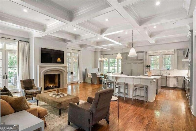 living room featuring french doors, beamed ceiling, hardwood / wood-style floors, and coffered ceiling