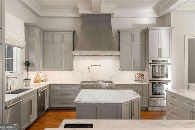 kitchen with appliances with stainless steel finishes, tasteful backsplash, gray cabinetry, custom range hood, and sink