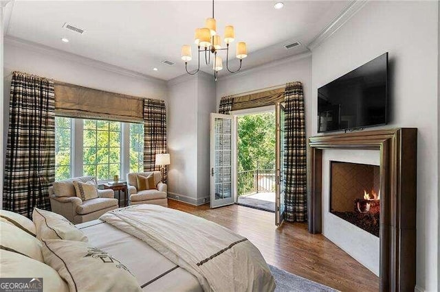 bedroom featuring access to exterior, hardwood / wood-style floors, an inviting chandelier, and multiple windows