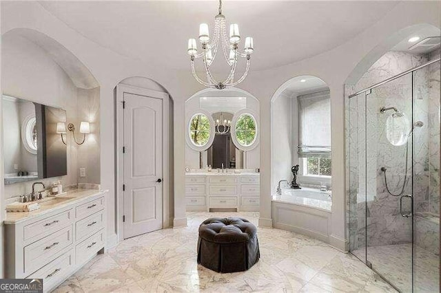 bathroom featuring plus walk in shower, vanity, and an inviting chandelier