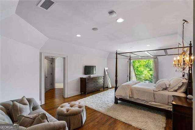 bedroom featuring a notable chandelier, dark hardwood / wood-style flooring, and vaulted ceiling