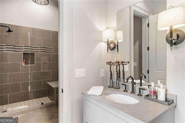 bathroom with tile patterned flooring, vanity, and tiled shower