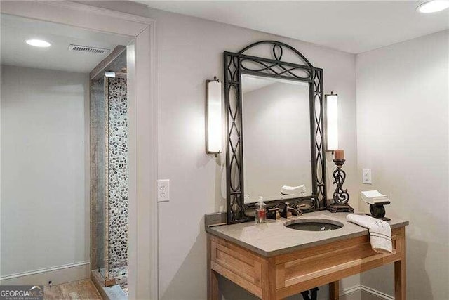 bathroom with wood-type flooring, walk in shower, and sink