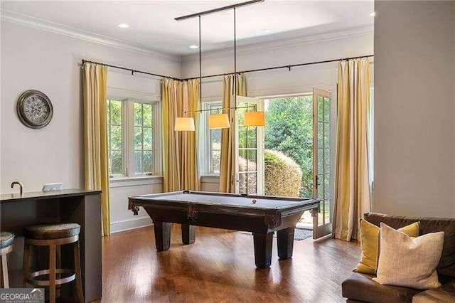 recreation room featuring indoor bar, dark wood-type flooring, ornamental molding, and billiards