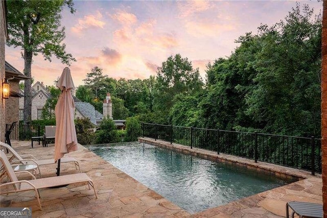 pool at dusk with a patio